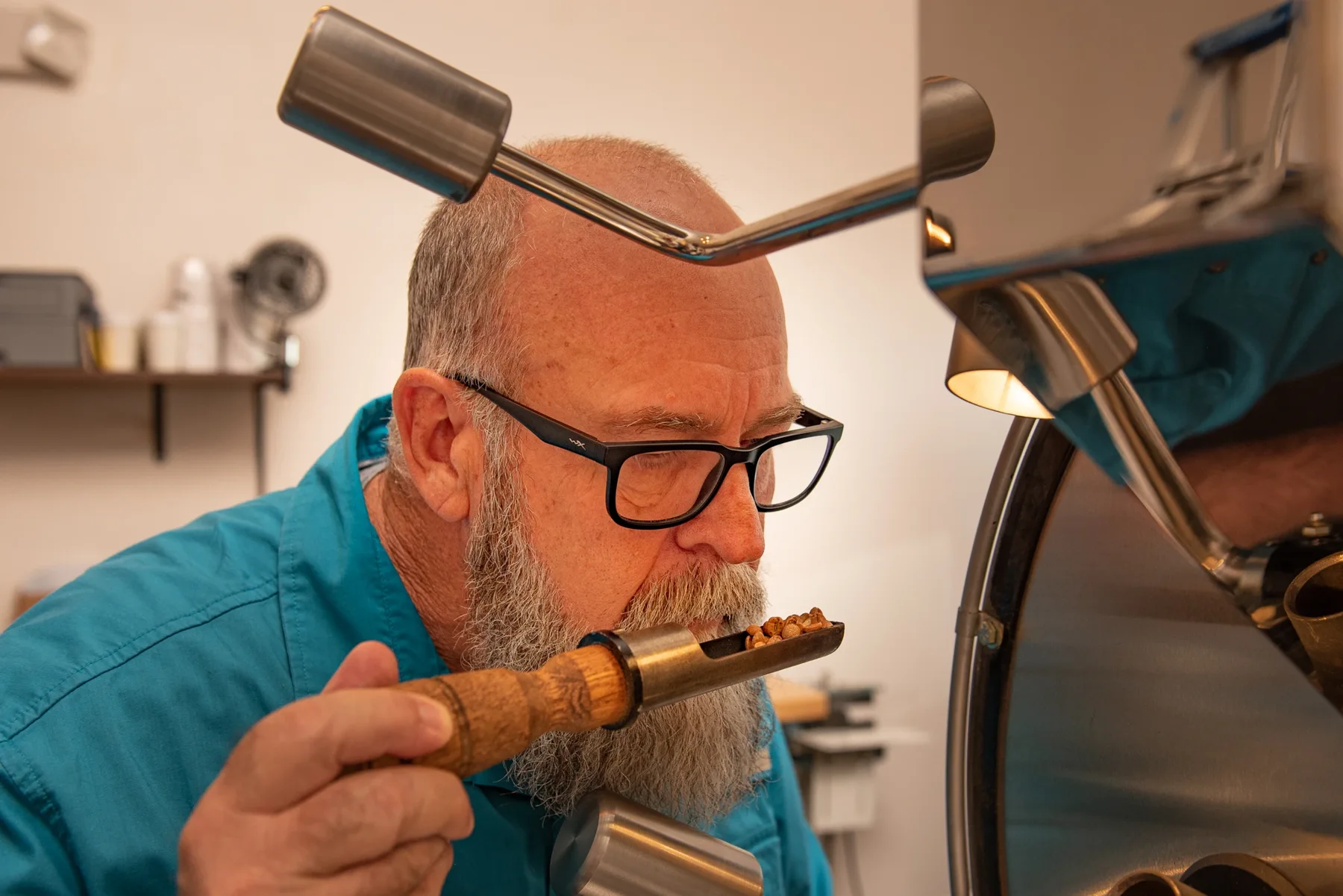 Michael Fewson assessing a coffee sample beside the roaster